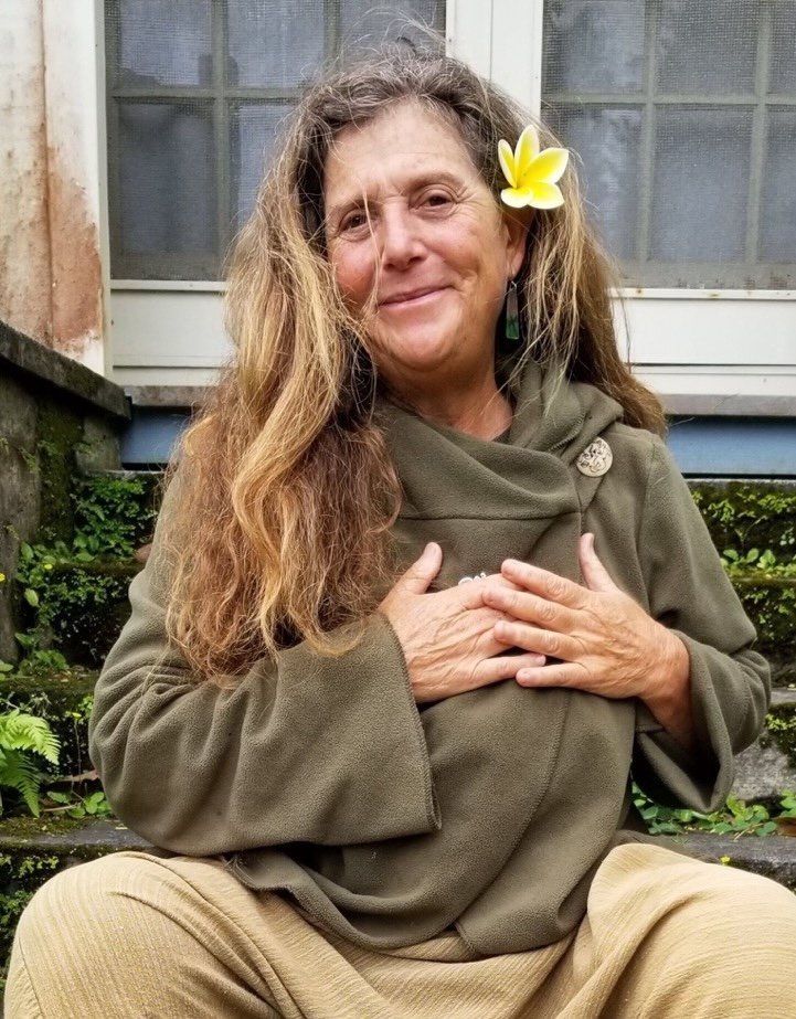 Donna Maltz in a serene namaste pose overlooking the Hawaiian coastline